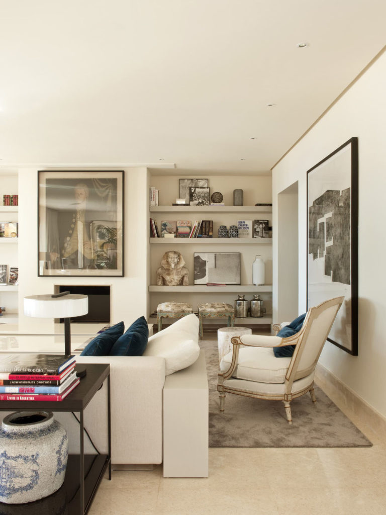 living room with a shelf with craft pieces such as sculptures and vases.
